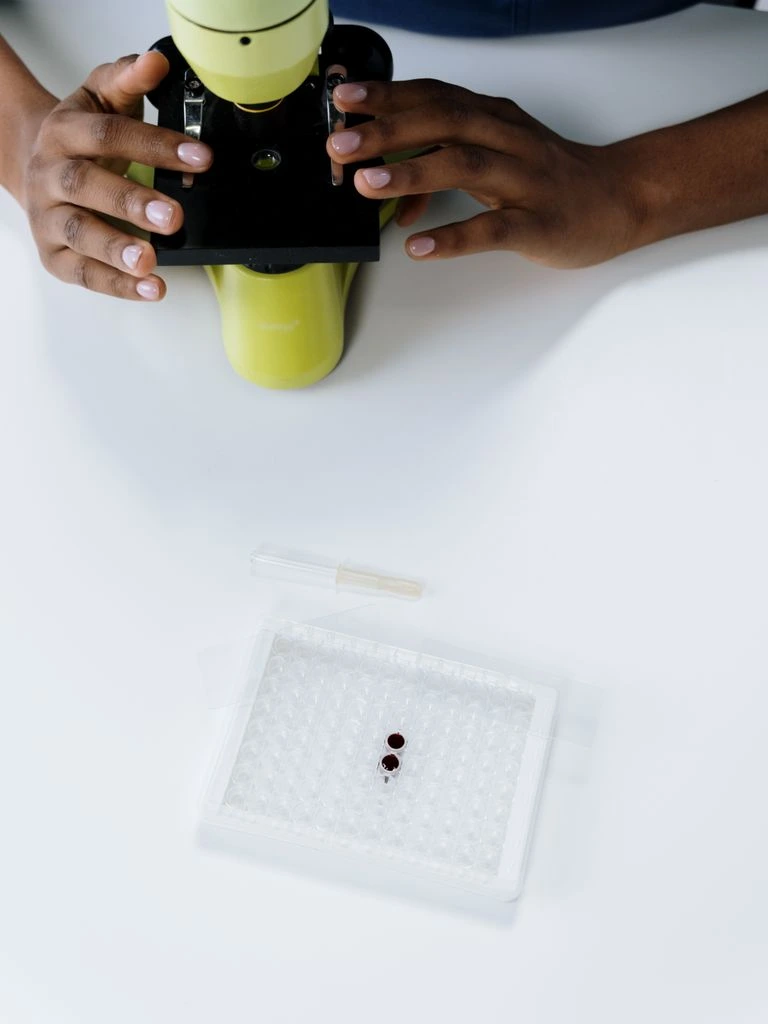 Scientist's hands holding a sample vial over a printed lab report